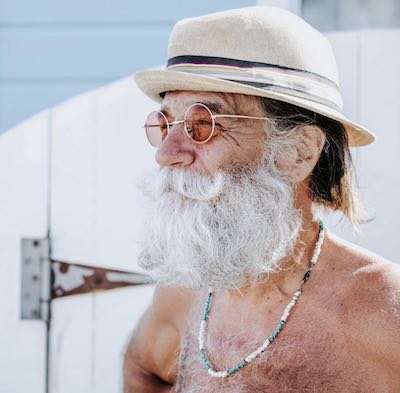 older man on beach wearing sunglasses